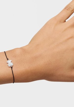 Pulsera de cordón negro con un charm en forma de oso de plata, superficie lisa, diseño simple y longitud ajustable.