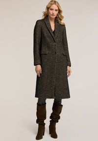 Schwarzer und weißer Fischgrät-Mantel mit taillierter Silhouette, Reverskragen, einer einzelnen Knopfschließe und zwei Fronttaschen.