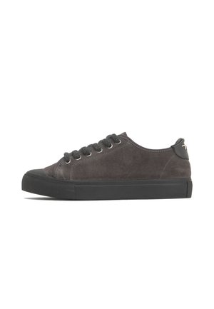 Zapatilla baja de ante gris oscuro con suela y puntera de goma negra, cierre de cordones y detalles cosidos sobre fondo blanco.