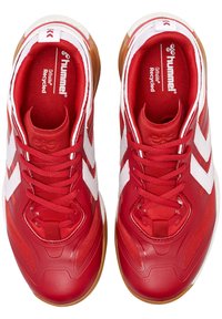 Chaussures de sport rouges avec des accents blancs, fabriquées à partir de matériaux synthétiques. Présentent une surface texturée et une semelle en caoutchouc. Comprennent des lacets et un logo.