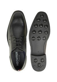 Zwarte leren nette schoen met afgeronde neus, vetersluiting en een rubberen zool met textuur en ronde gripjes. Gemarkeerd met maat 42.