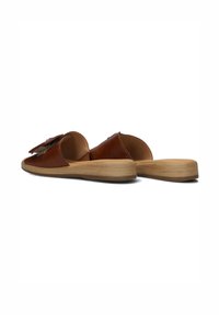 Brown leather slide-on shoes with a rounded toe, featuring a textured strap detail, and a wooden platform sole.