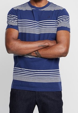T-shirt in cotone blu con righe bianche orizzontali, scollatura rotonda e maniche corte. Presenta una silhouette aderente e un design minimalista.