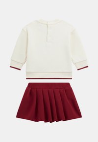 Completo a due pezzi composto da una felpa crema con accenti bordeaux e una gonna plissè bordeaux, realizzato in un tessuto morbido e confortevole.