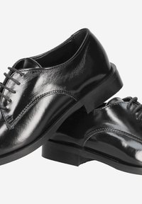 Schwarze Leder-Halbschuhe mit glänzender Oberfläche, klassischem Schnürdesign und einer flachen Gummisohle.