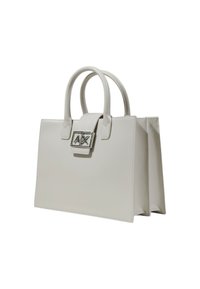 Borsa a mano bianca in pelle strutturata con due manici, forma quadrata, chiusura centrale con fibbia argentata riportante le lettere "AX". Texture liscia, design minimale.