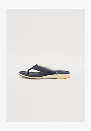 Tumed flip-flop sandaalid tekstureeritud rihmaga ja pehme, kerge tallaga, millel on kollane aktsent ja reljeefne bränding küljes.