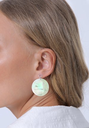 Runde Ohrringe aus schillerndem Muschelmaterial, mit einer glatten Textur und hellgrünen Farbtönen, die mit einer silberfarbenen Schlaufe befestigt sind.