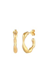Orecchini a cerchio in oro con un design ondulato e organico; superficie texture; chiusura a perno; forma simmetrica con spessori variabili.
