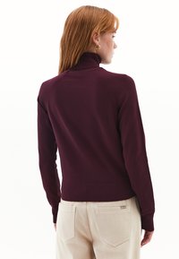 Bordeaux coltrui gemaakt van textuurmateriaal, met ribgebreide manchetten en zoom, in een fitted silhouet en raglanmouwen.