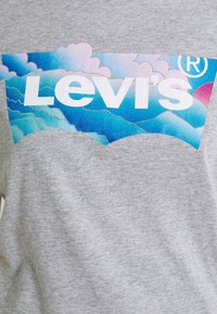 Šedé bavlněné tričko s velkým logem Levi's a grafickým designem v modré a růžové barvě připomínající mraky a vlny.