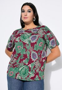 Kurzärmliges Oberteil in Bordeauxrot mit grünem und blauem Paisley-Muster. Aus leichtem Stoff gefertigt, mit rundem Ausschnitt und lockerer Passform.