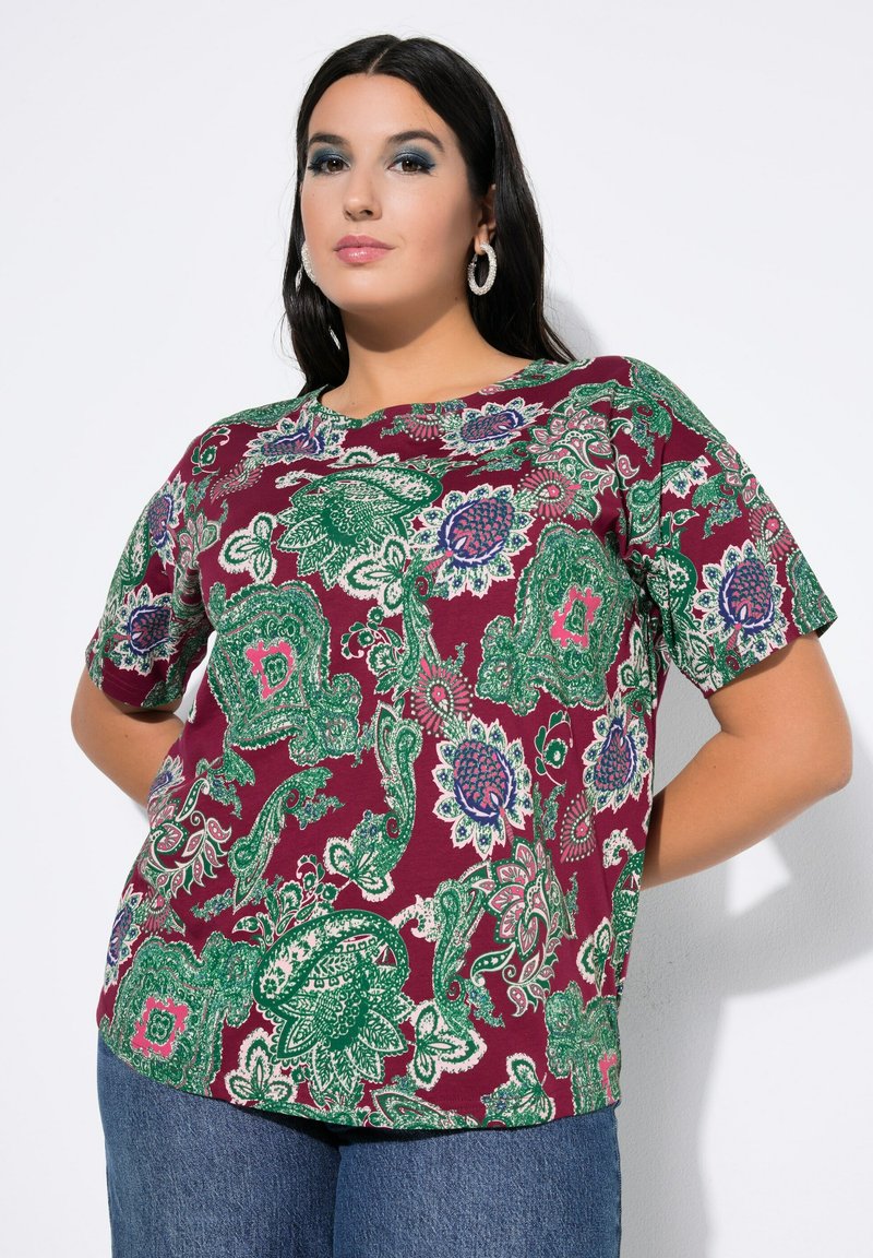 Kurzärmliges Oberteil in Bordeauxrot mit grünem und blauem Paisley-Muster. Aus leichtem Stoff gefertigt, mit rundem Ausschnitt und lockerer Passform.