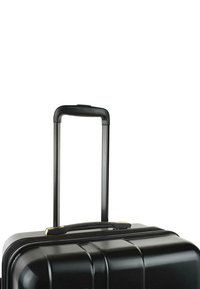 Maleta rígida negra con un diseño texturizado, asa retráctil y acentos dorados. Cuenta con una cremallera robusta y una forma aerodinámica.