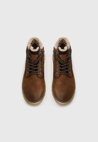 Brune læder ankelstøvler med en blød, cremefarvet faux fur-foring, metaløjer og teksturerede snørebånd. Robust sål med et let grebsmønster.