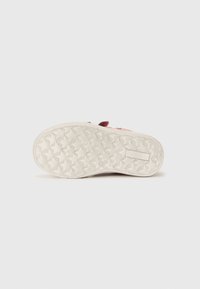 Suola della scarpa con un design in gomma caratterizzato da un motivo a stella, colore beige chiaro e grip testurizzato per una buona aderenza. Sottolineata da un bordo di un rosa intenso.