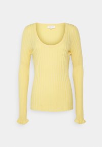 Top jaune en maille côtelée à manches longues avec encolure dégagée et légers détails de volants aux poignets, présenté sur un fond uni.