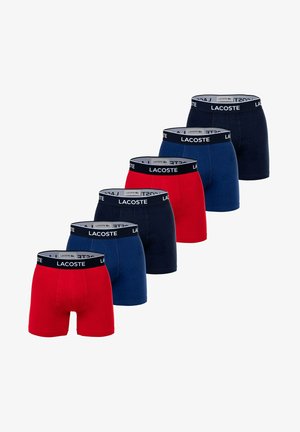 Pack of five men's boxer shorts featuring red and navy blue colors. Each pair has an elastic waistband with "LACOSTE" branding. Cotton material.