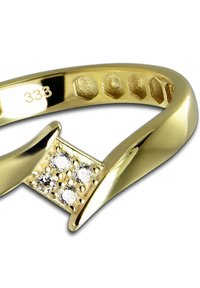 Bague en or présentant un design incurvé et fendu avec quatre petites pierres précieuses claires disposées en carré. Marquée "333" à l'intérieur.