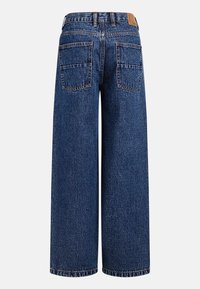 Τζιν παντελόνια με φαρδιά μπατζάκια σε σκούρο μπλε, με ψηλή μέση, δύο πίσω τσέπες και αντίθετη ραφή. Το υλικό φαίνεται ανθεκτικό και με υφή.