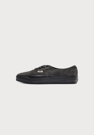Тъмносив нисък спортен обувка Vans с горна част от велур, черна гумена подметка, връзки отпред и малък етикет с логото на Vans отстрани.