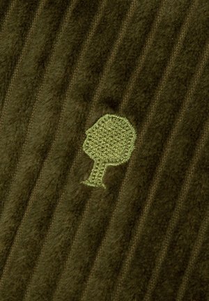 Tessuto verde a coste con texture morbida, caratterizzato da un logo ad albero ricamato di un verde chiaro. Le righe sono lievemente evidenti sulla superficie.