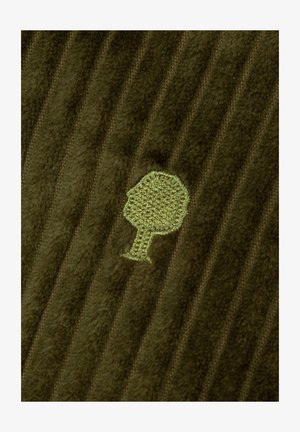 Grüner gerippter Stoff mit weicher Textur, der ein hellgrünes gesticktes Baum-Logo zeigt. Die Streifen sind subtil über die Oberfläche ausgeprägt.