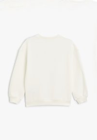 Sudadera crema clara con cuello redondo acanalado, mangas largas y puños elásticos. Textura suave, corte relajado y sin patrones ni logotipos visibles.