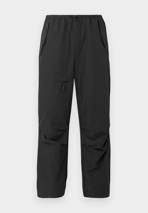 Schwarze, leichte Hose mit einem elastischen Bund, seitlichen Taschen und einer lockeren Passform. Glatte Textur, keine sichtbaren Muster oder Akzente.