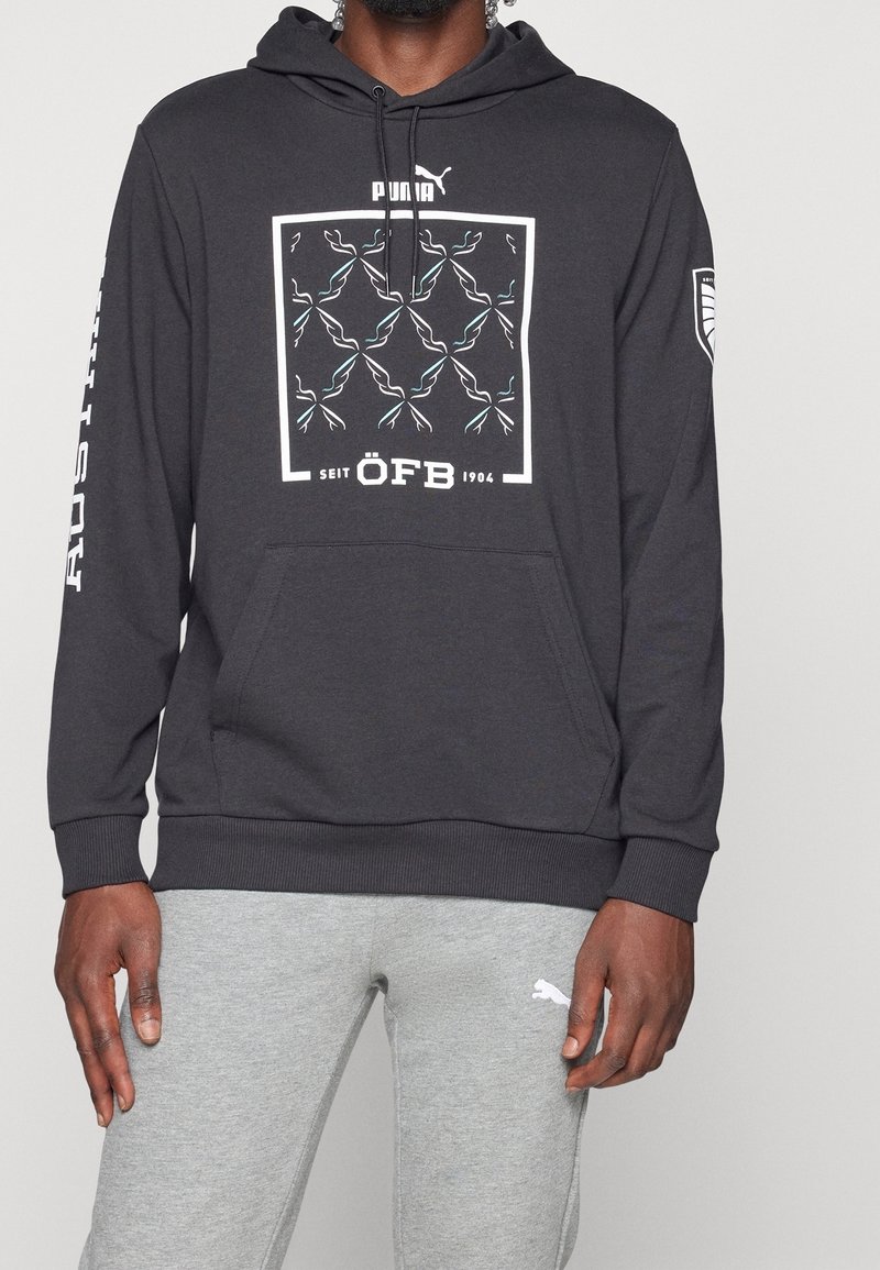 Felpa grigia scura in misto cotone, con stampa grafica in bianco e teal, tasca a canguro e polsini a coste. Logo sulla manica.