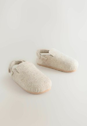 Grå føleslipper med åben bag og rund tå, med en glat tan- sål. Stoffet har en subtil tekstur og et let mønster.