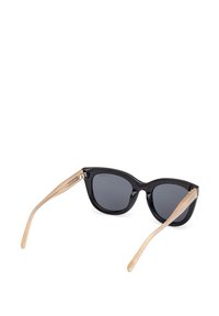 Černé sluneční brýle ve tvaru kočičích očí se šedými skly a béžovými stranami. Rámečky jsou lesklé s hladkým povrchem a jemnými metalickými detaily na pantících.