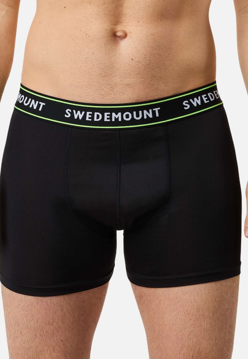 Czarne bokserki wykonane z rozciągliwej tkaniny, z szerokim pasem w talii z napisem "SWEDEMOUNT" w kolorze białym i zielonym.