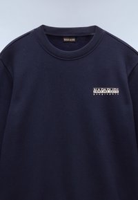 Navyblauwe sweatshirt met geribbelde ronde hals, logo op de borst in het wit, gemaakt van zachte stof. Eenvoudig ontwerp, gemiddeld gewicht, casual fit.