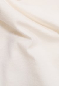 Helle Stoffcreme mit glatter Textur und leichtem Fall, ausgestattet mit einem Strickmuster und sanfter Oberfläche, ideal für verschiedene textile Anwendungen.