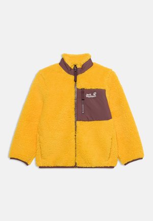 Gul fleecejakke med brun lynlås og brystlomme med Jack Wolfskin-logo på ensfarvet baggrund.