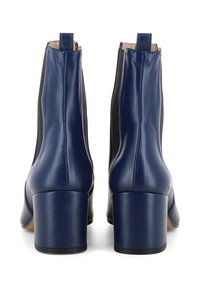 Bottes de cheville en cuir navy avec des panneaux latéraux noirs, un talon carré et un bout arrondi ; texture lisse et détails de couture visibles.