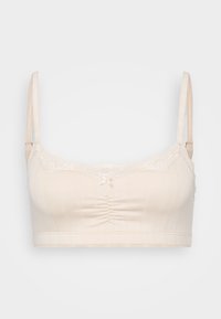 Lys beige bralette med blondertrim, rynket midtparti og justerbare stropper. Har ribbet tekstur og liten sløyfe foran.