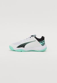Baskets de sport blanches avec un design noir et une semelle vert menthe. Présente un dessus texturé, un système de laçage et un détail de cheville à motifs.