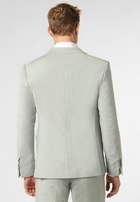 Hellgraue Anzugjacke aus strukturiertem Stoff. Taillierter Schnitt, einzelne Belüftung und geknöpfte Manschetten. Sauber verarbeitet mit einem weißen Hemdkragen.