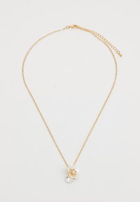 Collana in oro con un accento floreale bianco dettagliato e una pietra preziosa trasparente rotonda sottostante. Il design è delicato e intricato.