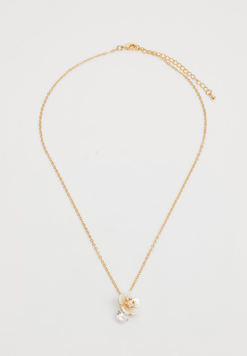 Collana in oro con un accento floreale bianco dettagliato e una pietra preziosa trasparente rotonda sottostante. Il design è delicato e intricato.