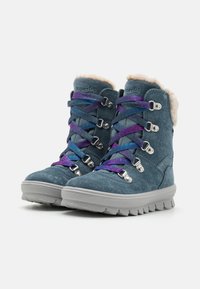 Botas de ante en color verde azulado con un collar de piel sintética, con cordones multicolores y herrajes plateados, suelas de goma elevadas y un diseño de punta redonda.