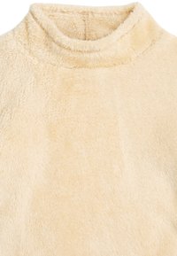 Cremig-beige Fleece-Stoff mit hohem Kragen, der eine weiche, plüschige Textur aufweist und eine glatte Oberfläche sowie einen subtilen Glanz besitzt.