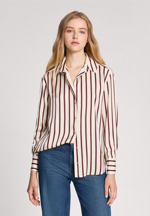 Camicia a righe color crema con strisce verticali marrone scuro, caratterizzata da un collo a camicia e maniche lunghe con polsini abbottonati.