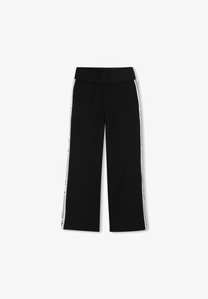 Pantalones negros de pierna ancha con una cinturilla suave, con franjas blancas a los lados con texto. La tela es suave con un acabado mate.