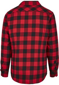 Rød og svart rutete flanellskjorte med lange ermer, knappejusteringer og spiss krave. Har et tradisjonelt rutedesign.