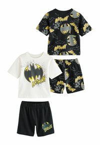 Batman-temat barnpyjamasset som består av en svart t-shirt med en gul logotyp, en vit t-shirt med grafik och svarta shorts med gula detaljer.
