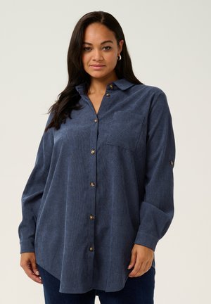 Blue button-up shirt with a collar, featuring a chest pocket, long sleeves, and gold-tone buttons on a textured fabric.