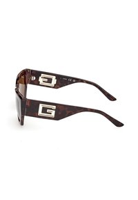 Zonnebril met schildpadmotief, dikke rechthoekige monturen en grote gouden "G"-logo's op de pootjes.